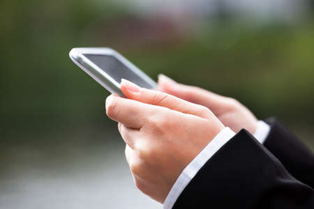 Cropped image of businesswoman using digital tablet outdoors
