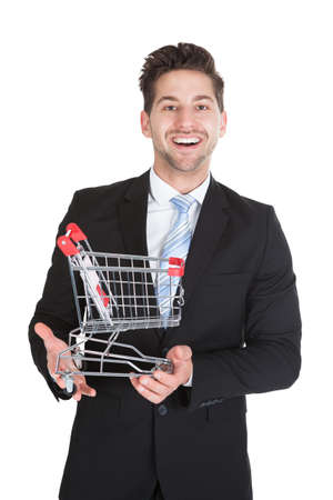 Portrait of young businessman with shopping cart model over white backgroundの写真素材