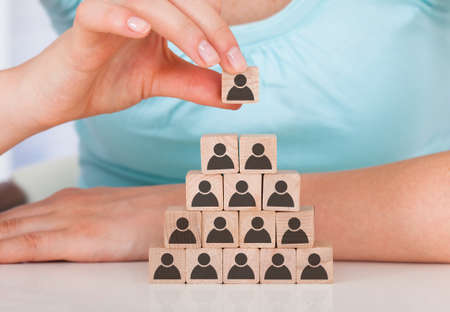 Midsection of young woman stacking wooden team blocks at tableの写真素材