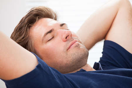 Closeup of mid adult man sleeping at homeの写真素材