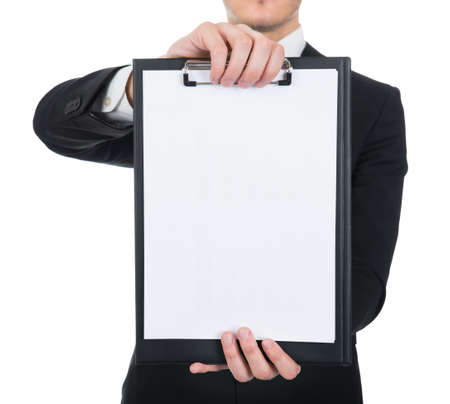Businessman holding clipboard with blank paper against white background