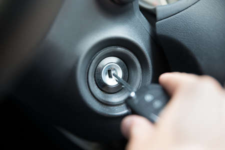 Closeup of man inserting key to start car