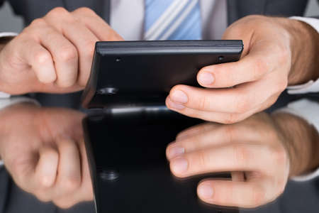 Accountant calculating tax using calculator at the tableの写真素材