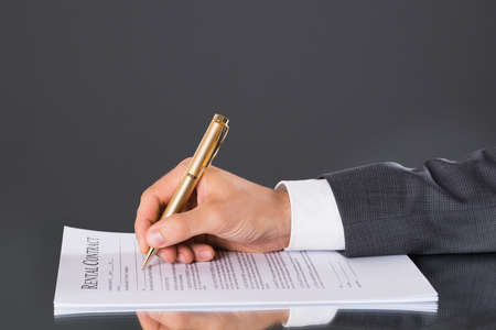 Businessman hand signing business contract. Closeup shot