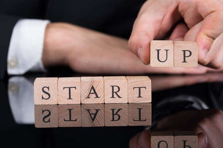 Cropped image of businessman arranging Startup blocks on desk