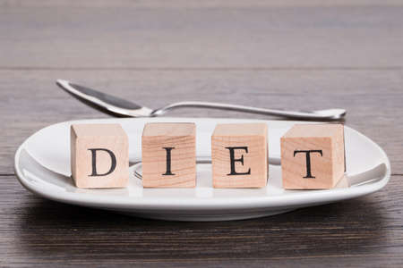 Wooden letters on dish plate in dieting conceptの写真素材