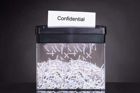 Shredded destroying confidential document over black backgroundの写真素材