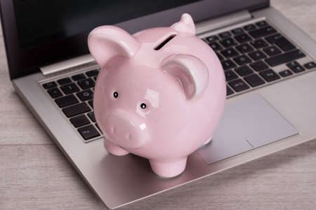 Piggybank on laptop keyboard in money saving conceptの写真素材