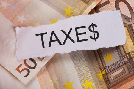 Closeup of Taxes sign on euro banknotes