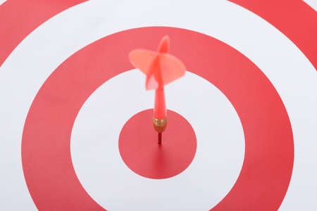 Closeup of dart on concentric red and white targetの写真素材