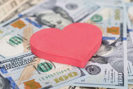 Closeup of red heart shape on dollar billsの写真素材