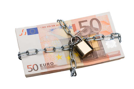 Closeup of metallic chain and padlock around euro bundle isolated over white backgroundの写真素材