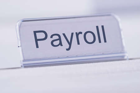 Closeup of Payroll tag on white tableの写真素材