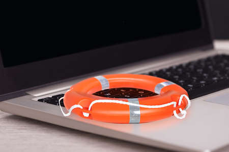 Closeup of orange buoy on laptop at tableの写真素材