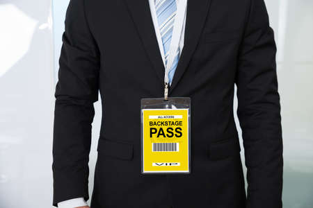 Midsection of businessman wearing backstage pass in officeの写真素材