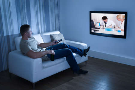 Portrait Of A Man Watching Television Sitting On Couch