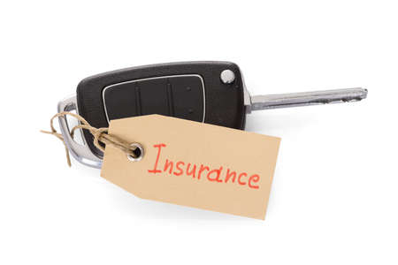 Close-up Of Key Attached With Insurance Tag On White Backgroundの写真素材