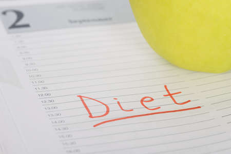 Close-up Of Diet Word And Green Apple On Diaryの写真素材