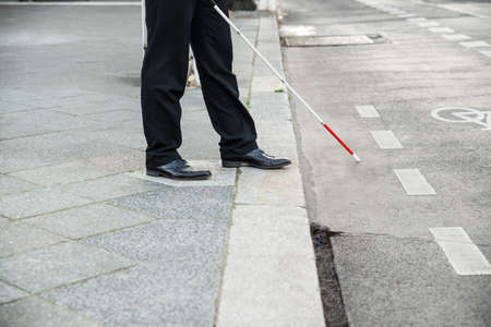 Low Section Of A Blind Person Crossing Streetの写真素材