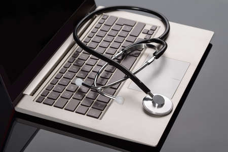 Medical Stethoscope Over Laptop Keyboard On Deskの写真素材