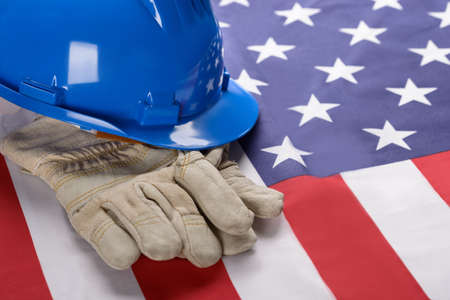 Close-up Of Blue Hardhat And Gloves On American Flagの写真素材