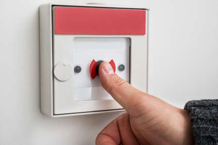 Close-up Of A Person's Hand Pressing Emergency Alarm Buttonの写真素材