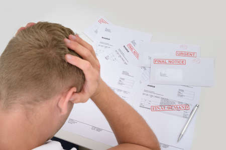 Frustrated Man With Unpaid Bills And Invoicesの写真素材