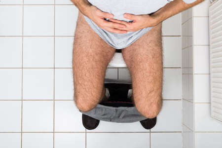 High Angle View Of A Man In Toilet Suffering From Stomachache