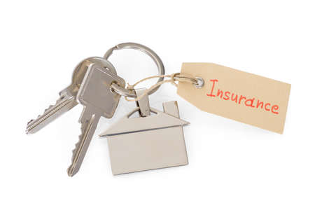 Close-up Of House Key With Insurance Tag On White Backgroundの写真素材