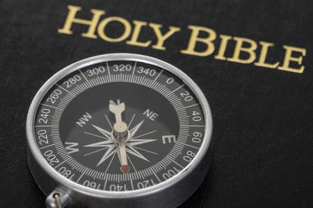 Close-up Of Compass Lying On Holy Bibleの写真素材