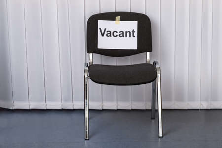 Office Chair With A Vacant Sign At Work Placeの写真素材