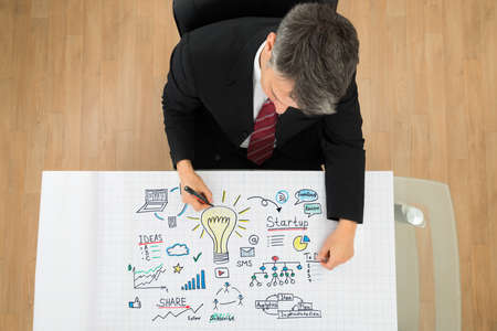 Businessman Drawing Startup Plan On Paper At Officeの写真素材