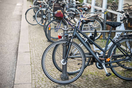 Many Bicycles Parked Against A Railing On Streetの写真素材