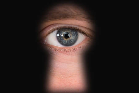 Close-up Photo Of Person's Seen Through Keyholeの写真素材