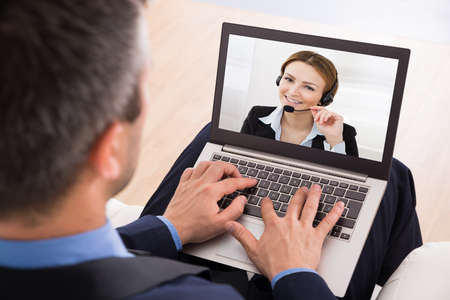 Businessman Video Chatting With Businesswoman On Laptopの写真素材