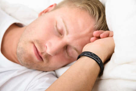 Close-up Of Young Man Sleeping Wearing Smart Wristband
