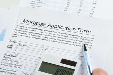 Pen And Calculator On Mortgage Application Form