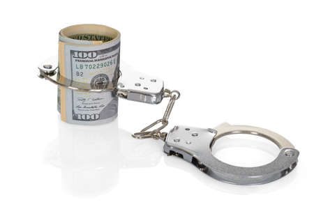 Close-up Of Rolled Up Dollar Bills With Handcuffs On White Backgroundの写真素材
