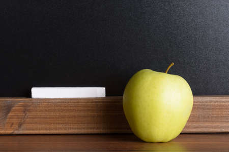 Green Apple And White Chalk In Front Of A Chalkboardの写真素材