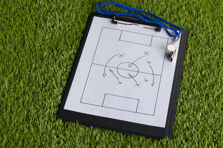 Whistle And Clipboard With Soccer Tactic Diagram On Green Pitchの写真素材
