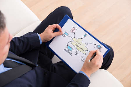 Businessman Sitting On Couch Drawing Cloud Computing Diagram On Paperの写真素材