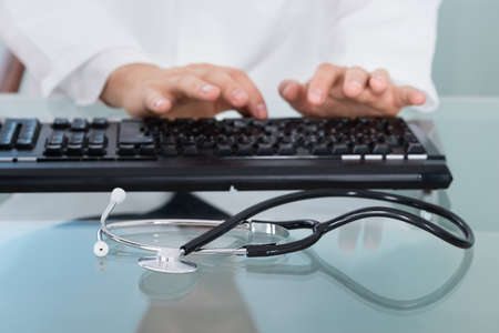 Close-up Shot Of Doctor Using Computer Keyboardの写真素材