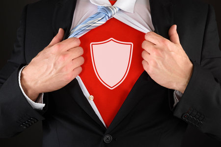 Close-up Of Businessman Pulling Shirt Showing A White Shield Symbol