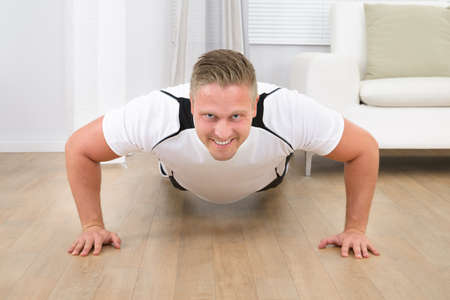 Muscular Sporty Man Doing Pushups In A Living Room