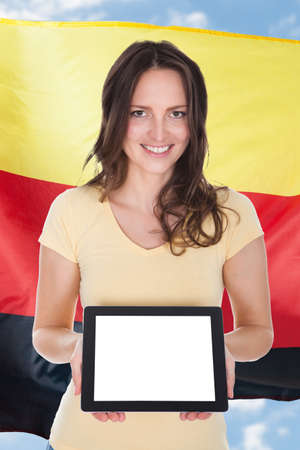 Young Woman In Front Of German Flag Holding Digital Tabletの写真素材