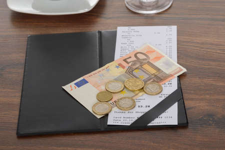 Close-up Of Bill With Euro Note On Wooden Tableの写真素材