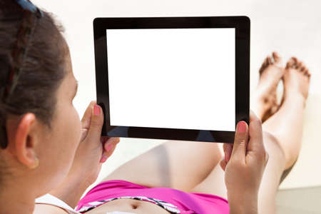 Young woman using digital tablet with blank screen at resortの写真素材