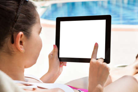 Young woman using digital tablet with blank screen at resortの写真素材