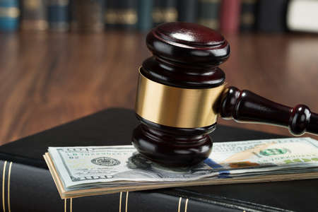 Close-up Of Gavel On A Stack Of American Banknote And Law Bookの写真素材