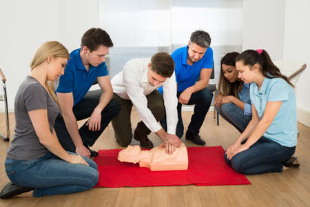 First Aid Instructor Showing Resuscitation Technique On Dummy First Aid Instructor Showing Resuscitation Technique On Dummy